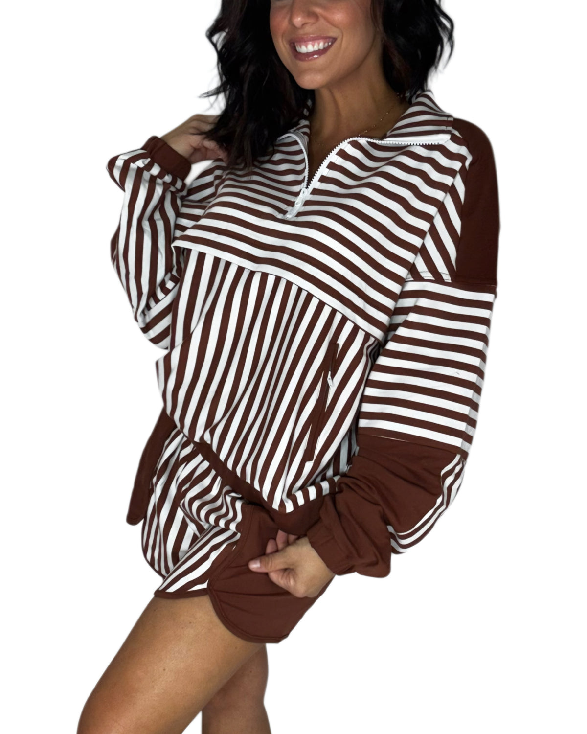 Side profile of a woman wearing a brown and white striped long-sleeve quarter-zip pullover top with solid brown cuffs and hem, shown against a plain white background.