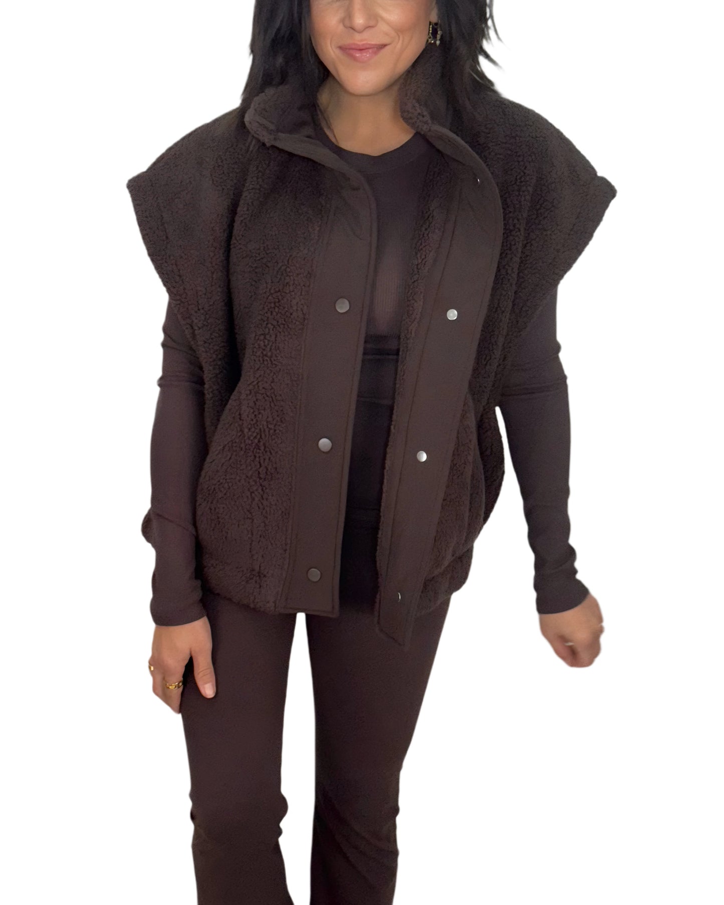 Full profile of a woman wearing a brown sherpa vest on a white background