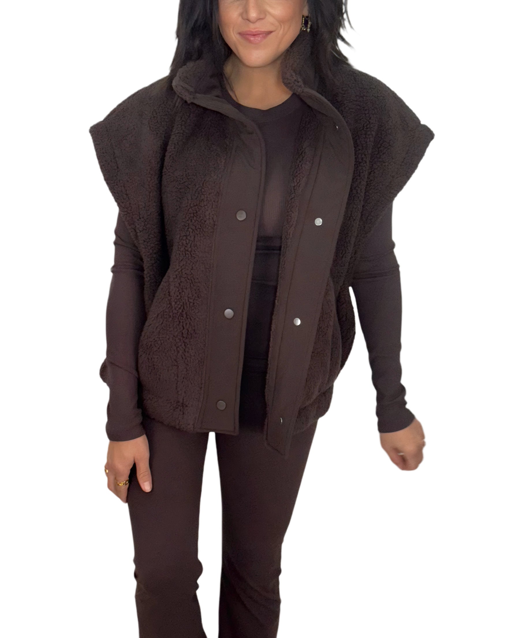 Full profile of a woman wearing a brown sherpa vest on a white background