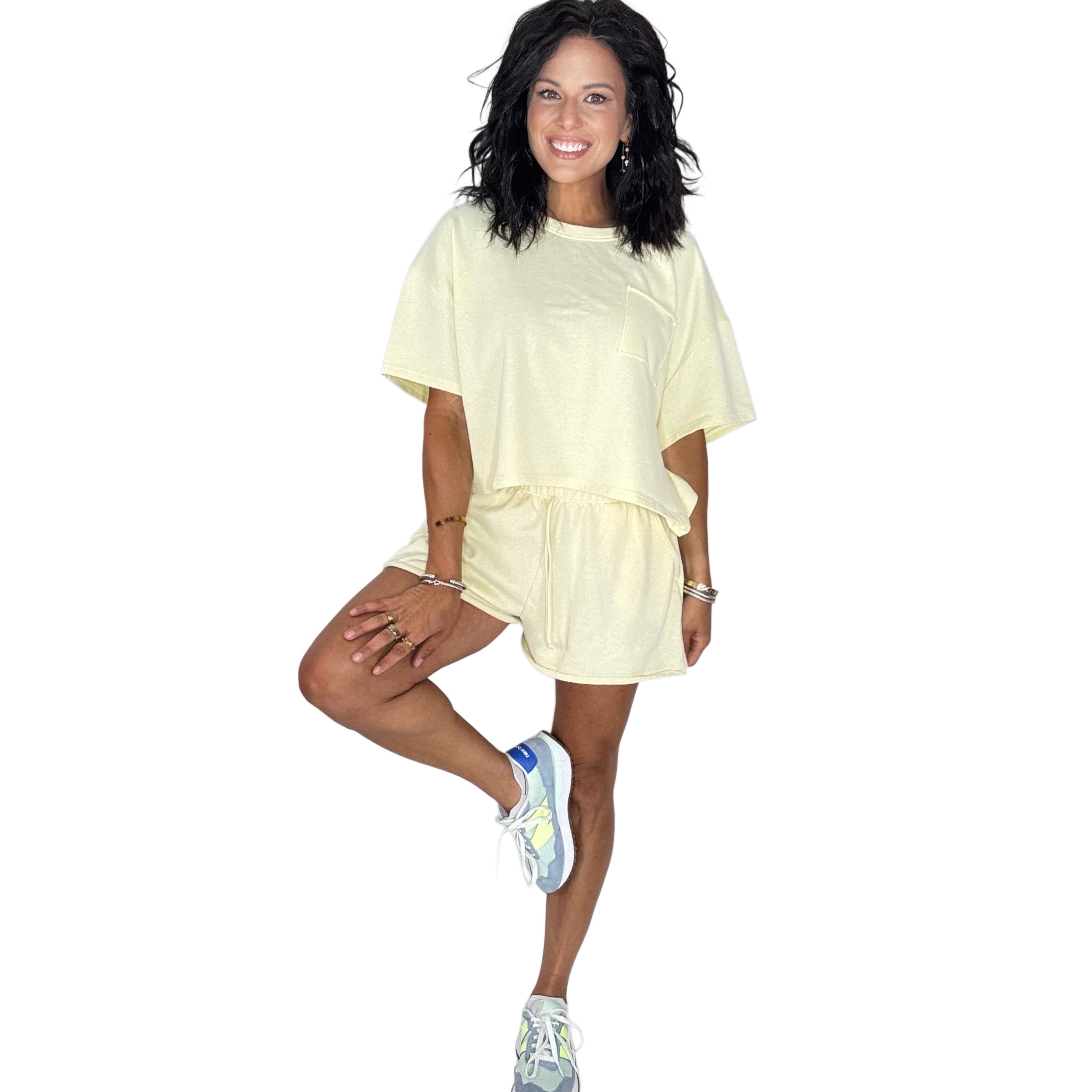 Woman wearing a pale yellow short set on a white background 