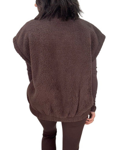 Back profile of a woman wearing a brown fleece vest  on a white background