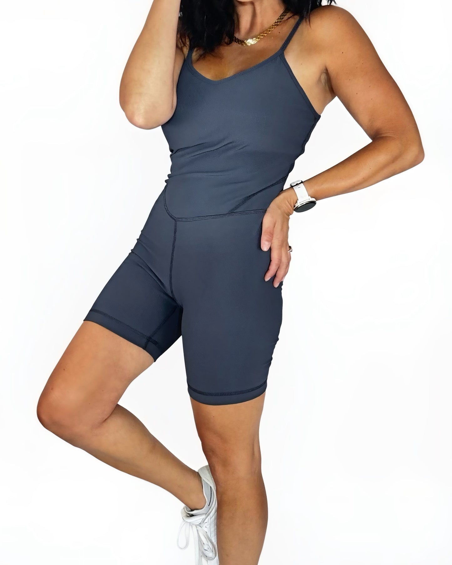 Person wearing a gray athletic ribbed romper on a white background