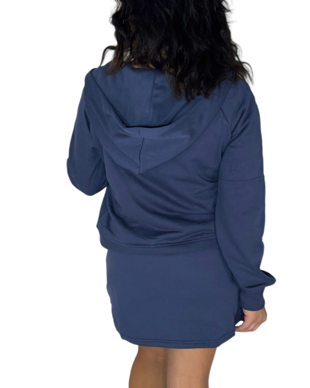 Avwoman shown from the back wearing a navy blue hooded sweatshirt and matching mini skort set against a plain white background.