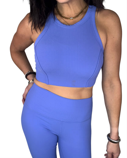 front profile of a woman wearing wearing a ribbed blue athletic outfit on a white background
