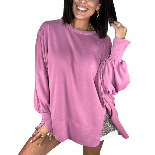 Woman wearing a pink oversized sweater on a white background