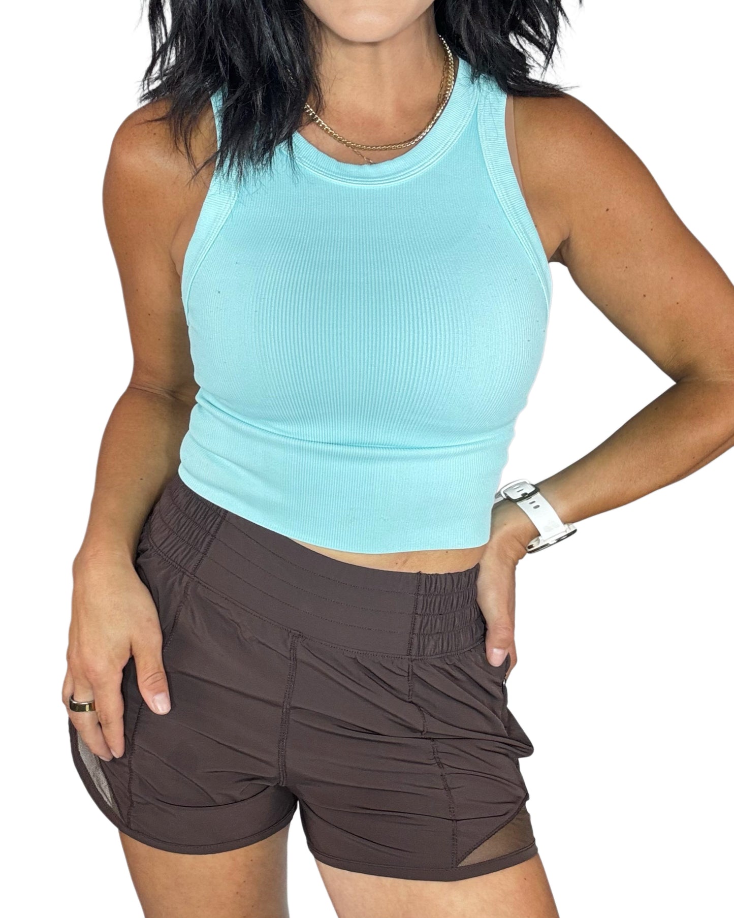 Woman wearing a light blue tank top and brown shorts on a white background
