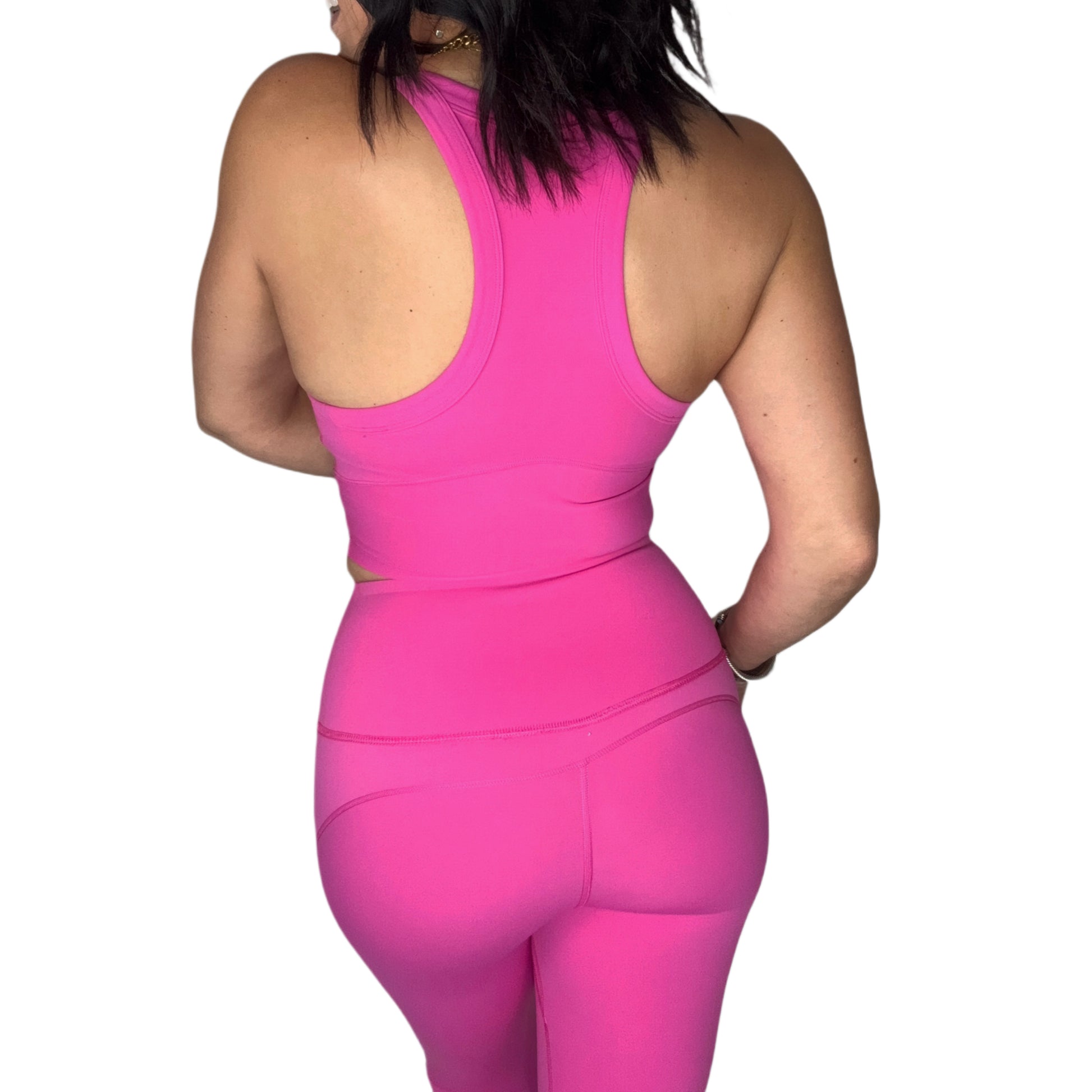 Back profile of a woman wearing a bright pink athletic outfit on a white background