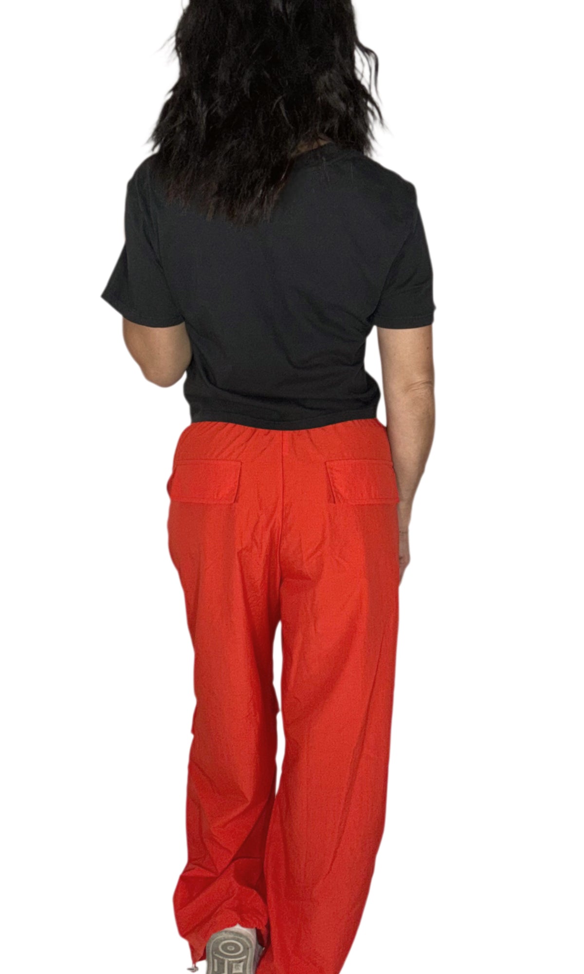 A person shown from the back wearing bright red straight-leg work pants with back patch pockets and a black t-shirt, against a plain white background.