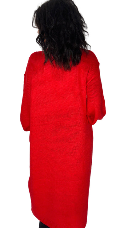 A person viewed from the back wearing a bright red ribbed knit sweater or long top against a plain white background.