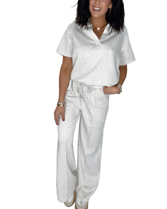 Woman wearing a light gray  lounge outfit with a white background