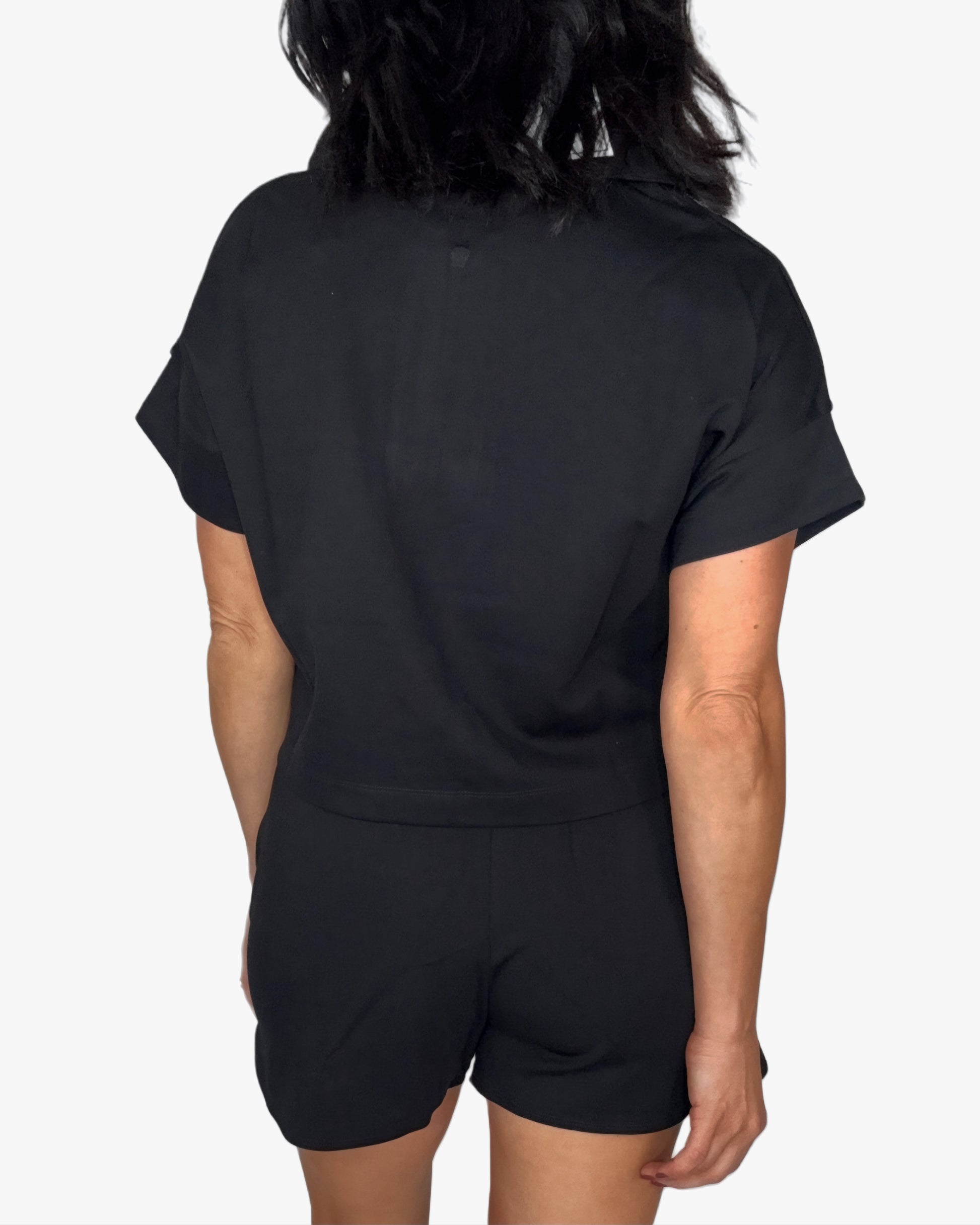 Back profile of a woman wearing a black short set on a white background