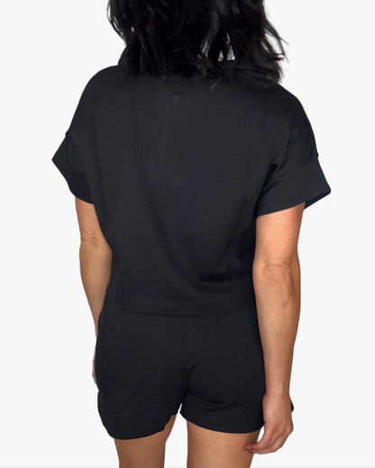 Back profile of a woman wearing a black short set on a white background