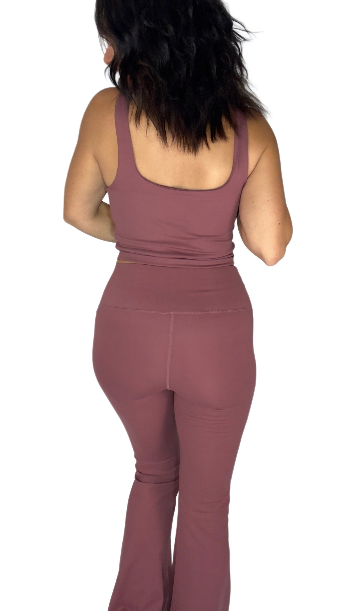 Back profile of a woman wearing a rosewood active pant set with matching tank and flared bottoms on a white background 