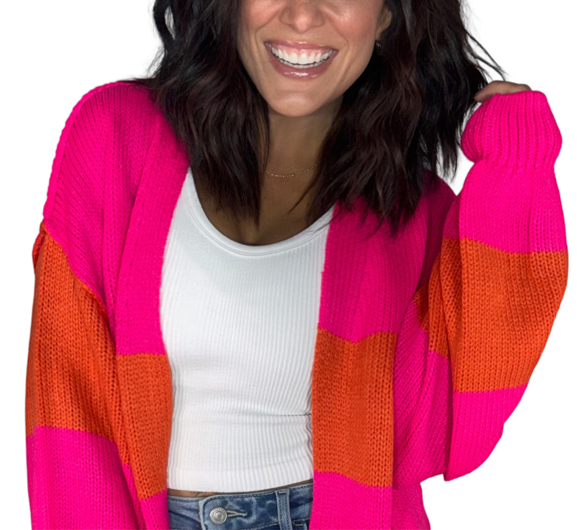 Close up of a woman wearing a pink and red cardigan with a white tank, on a white background 