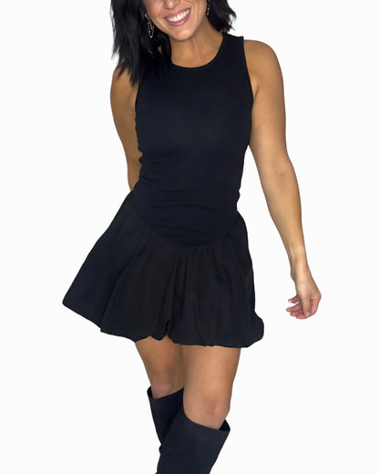 Woman wearing a black ribbed sleeveless bubbled dress on a white background