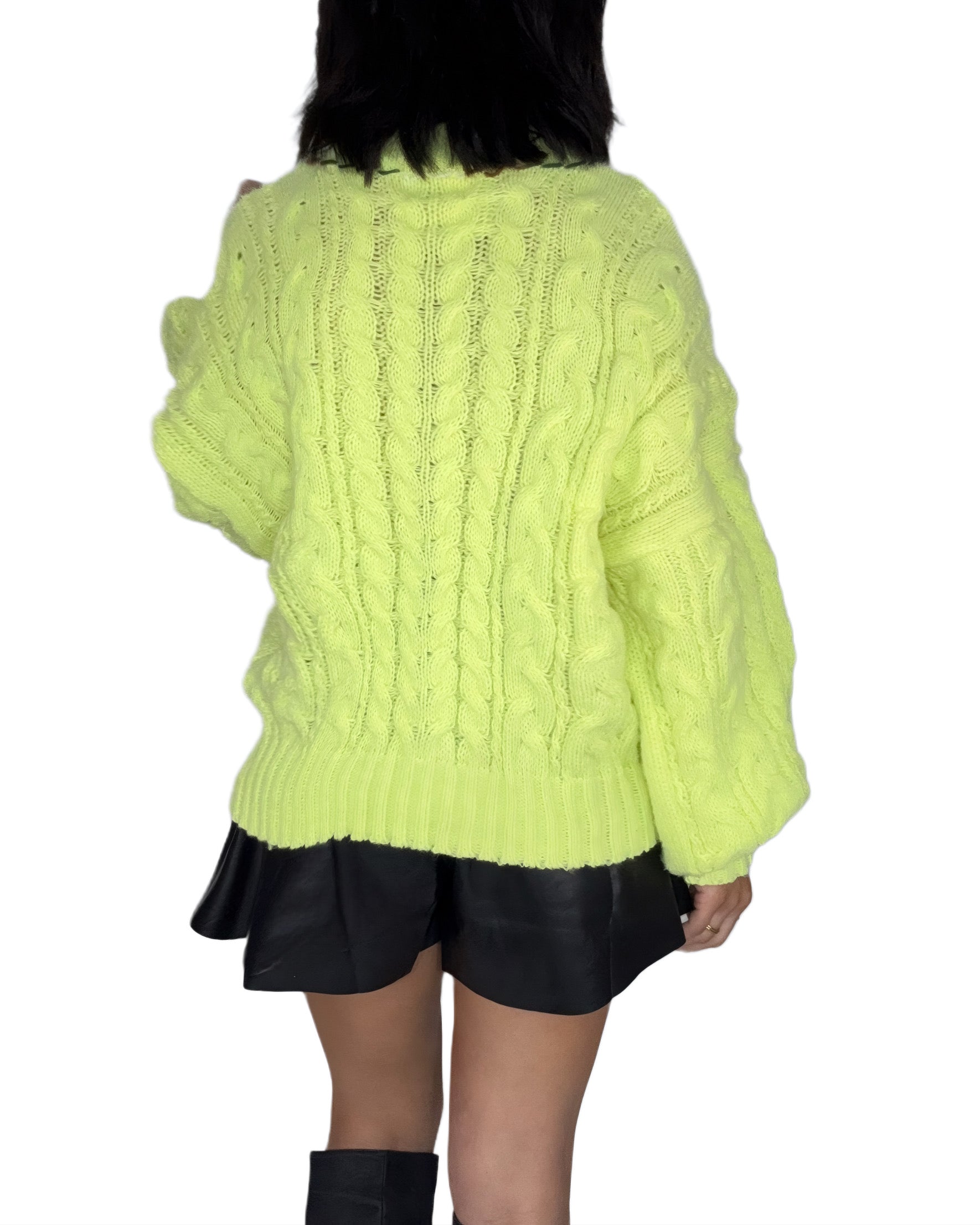 Back profile of a woman wearing a bright green cable knit sweater on a white background