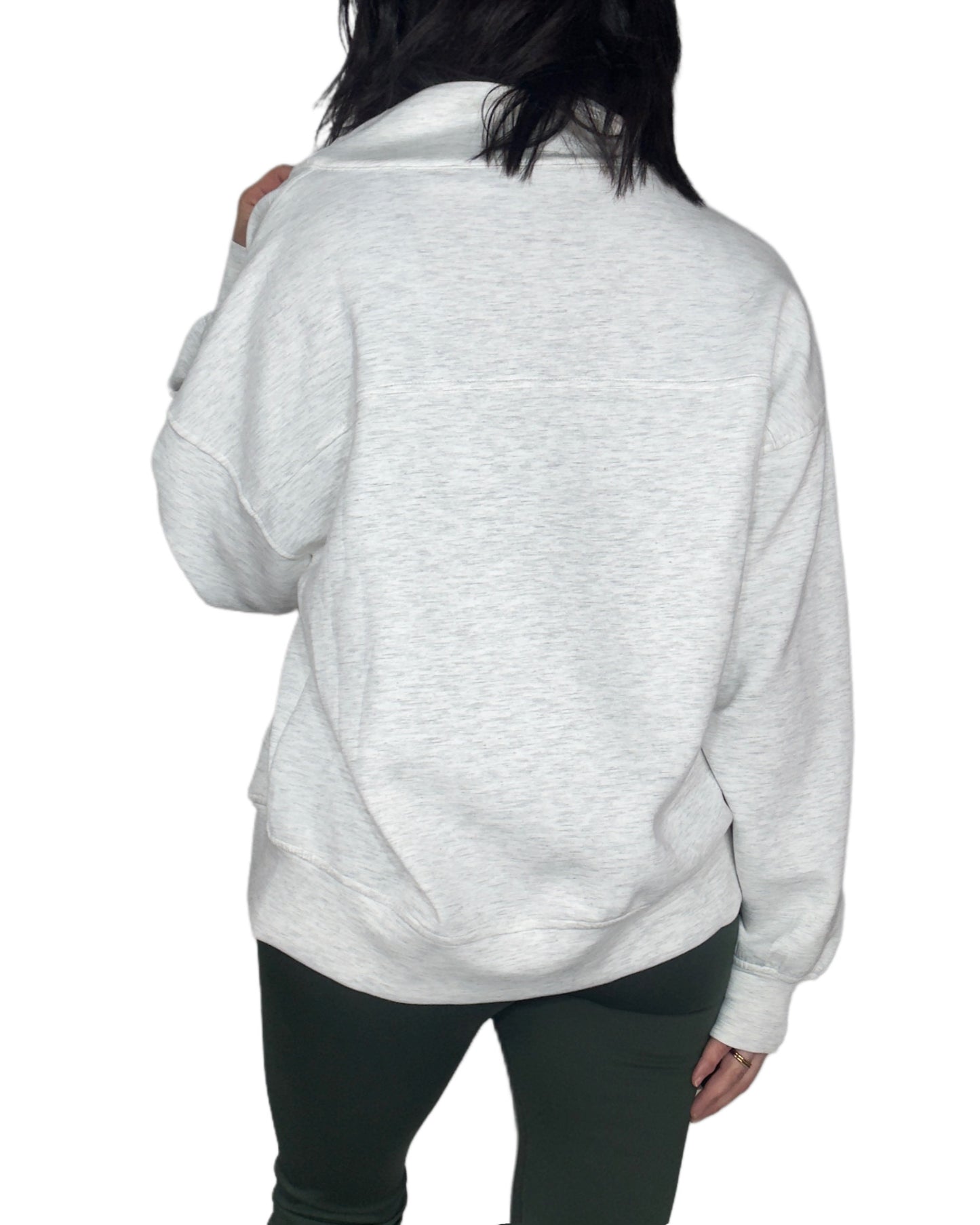 Back profile of a woman wearing a light gray sweatshirt on a white background