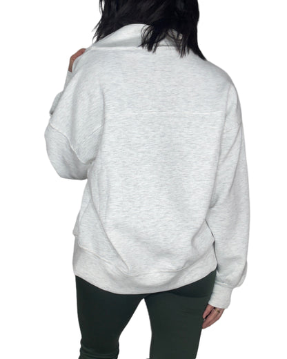 Back profile of a woman wearing a light gray sweatshirt on a white background