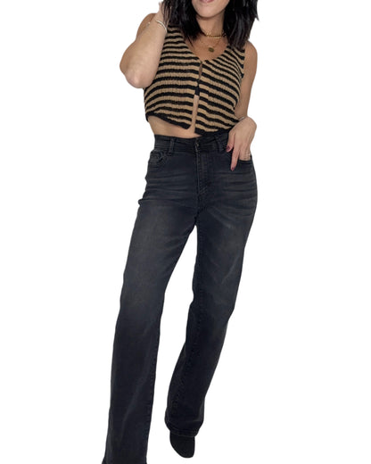 Person wearing a striped crop top and black jeans on a white background