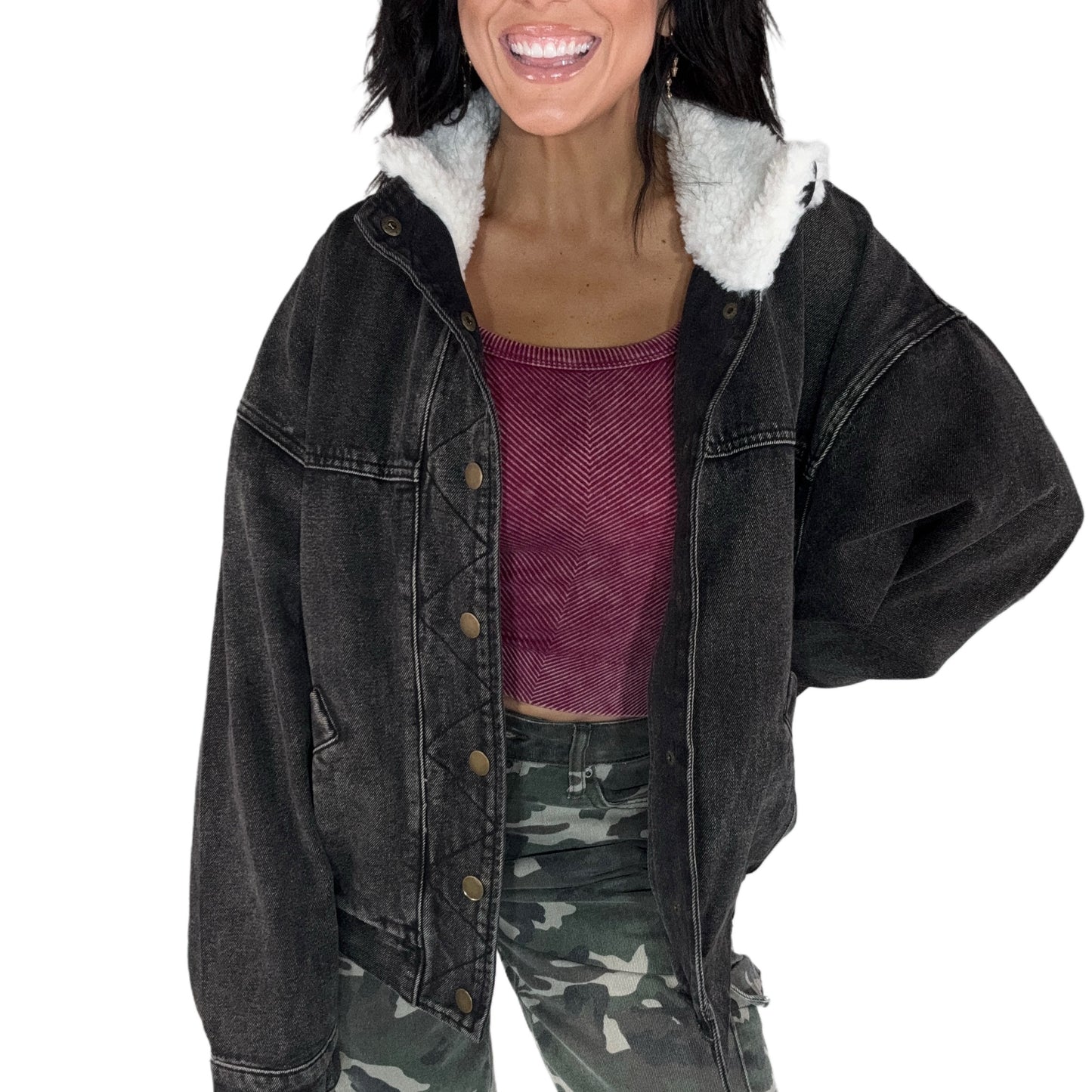 Woman wearing a black denim jacket with white fur lining on a white background