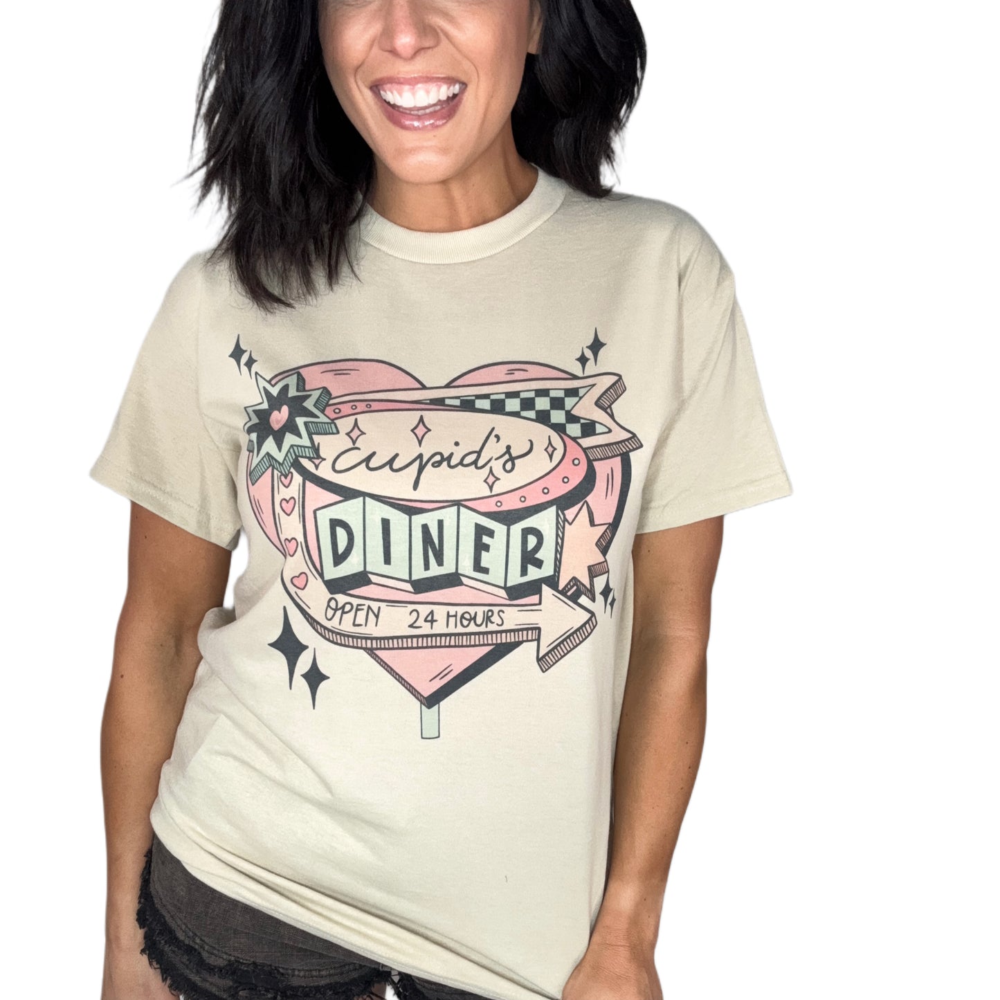 Woman wearing a sand color t-shirt with 'Cupid's Diner' graphic design on a plain background