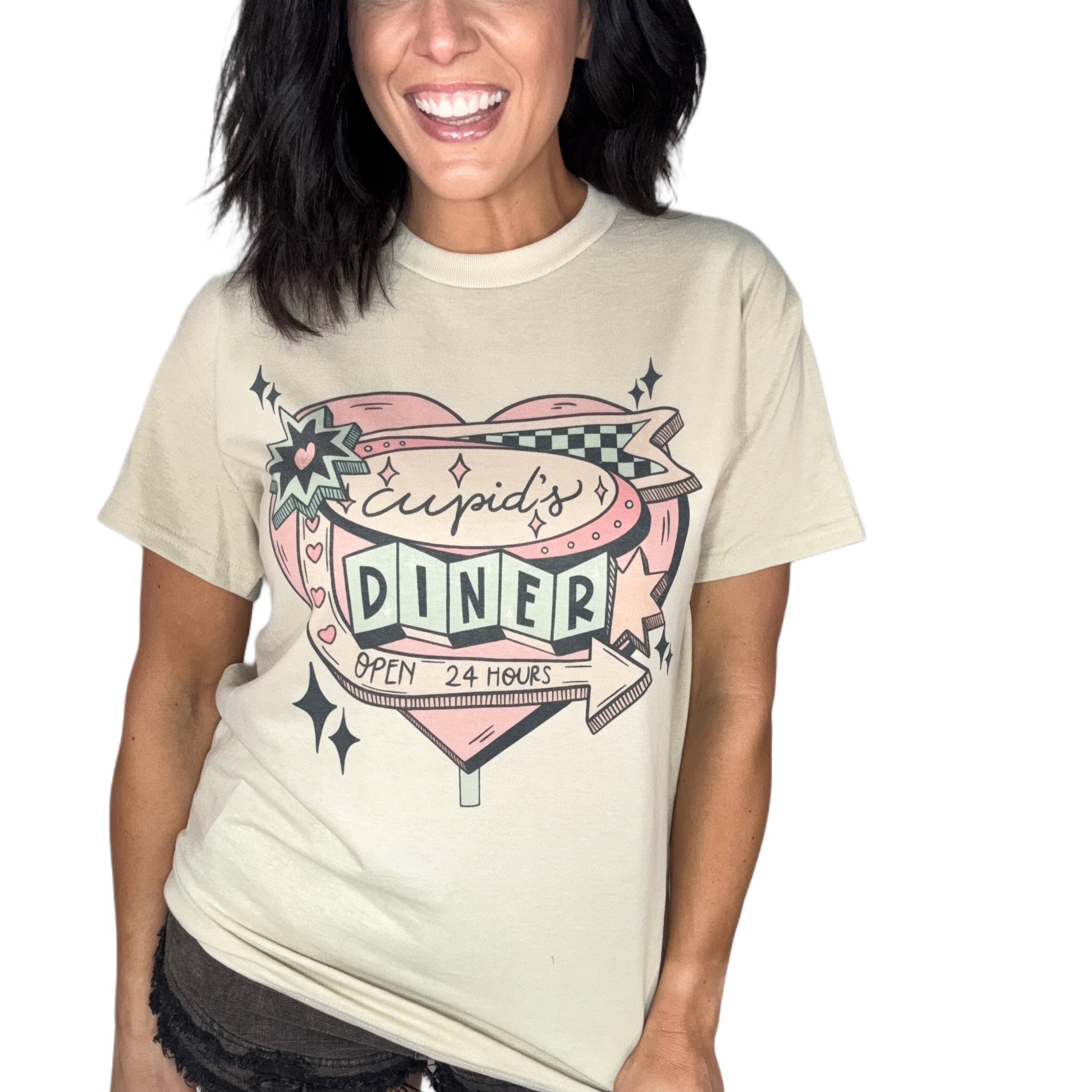 Woman wearing a sand color t-shirt with 'Cupid's Diner' graphic design on a plain background