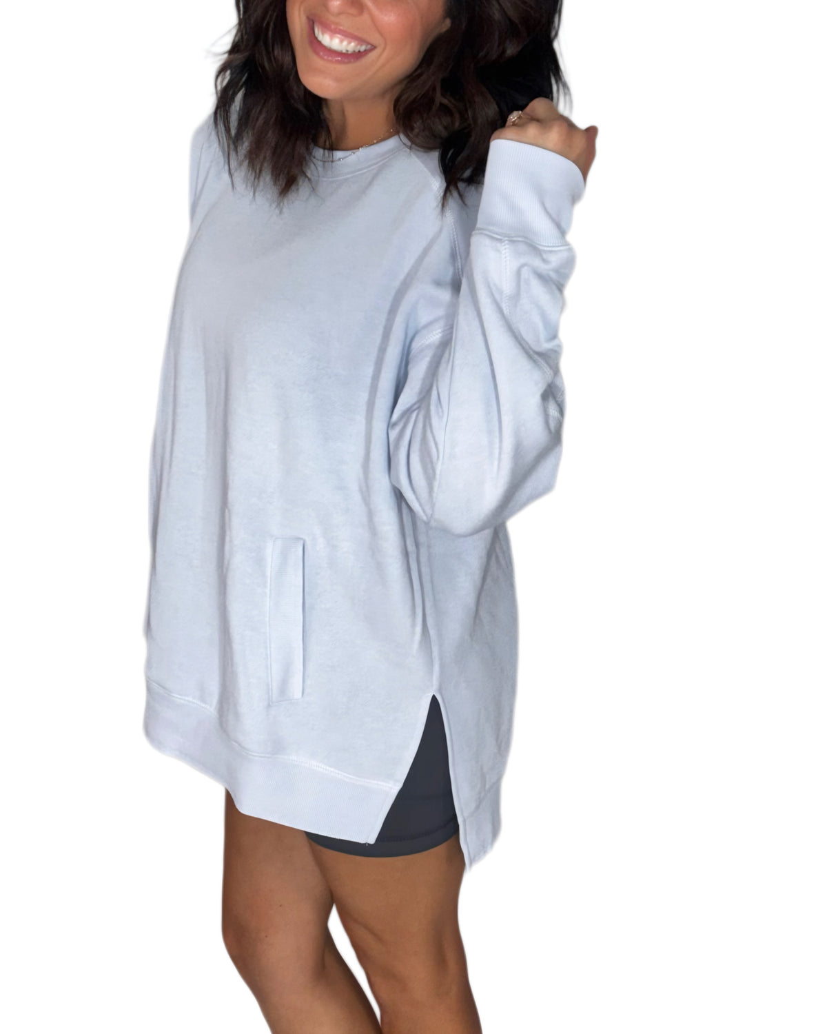 Side profile of a woman wearing a light blue sweatshirt on a white background 