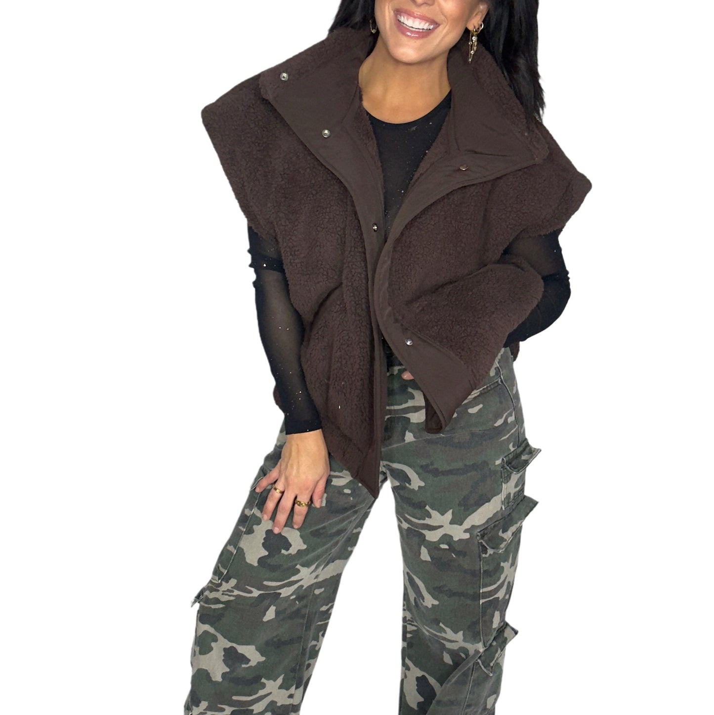 Woman wearing a brown vest and camouflage pants on a white background